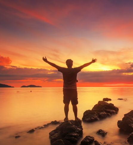 hyvinvoima valmennukseen osallistunut mies levittämässä kätensä veden äärellä